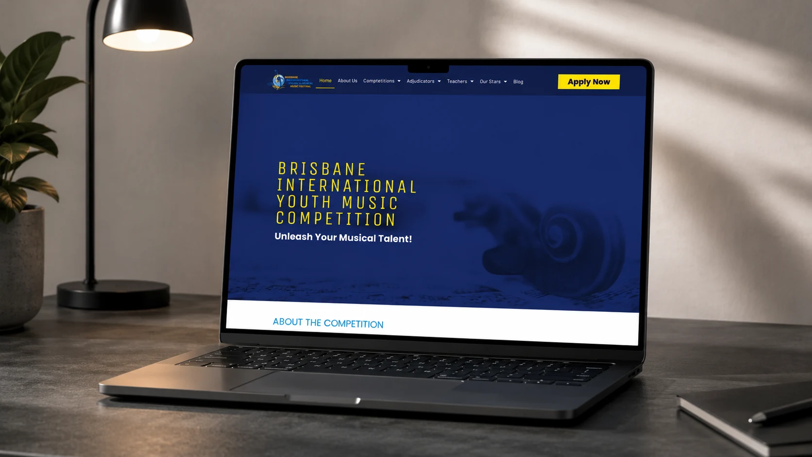 The Brisbane International Youth Music Competition home page on a laptop, showing the Apply Now button